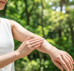 手のひらで首に日焼け止めを優しく塗る様子