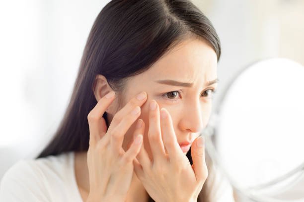 鏡で肌の状態を確認する女性