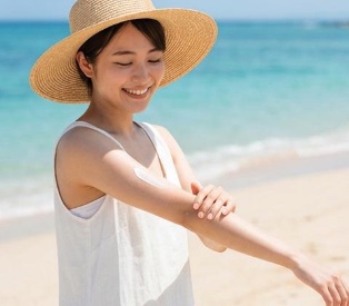 手のひらに日焼け止めを適量出して頬に塗る様子